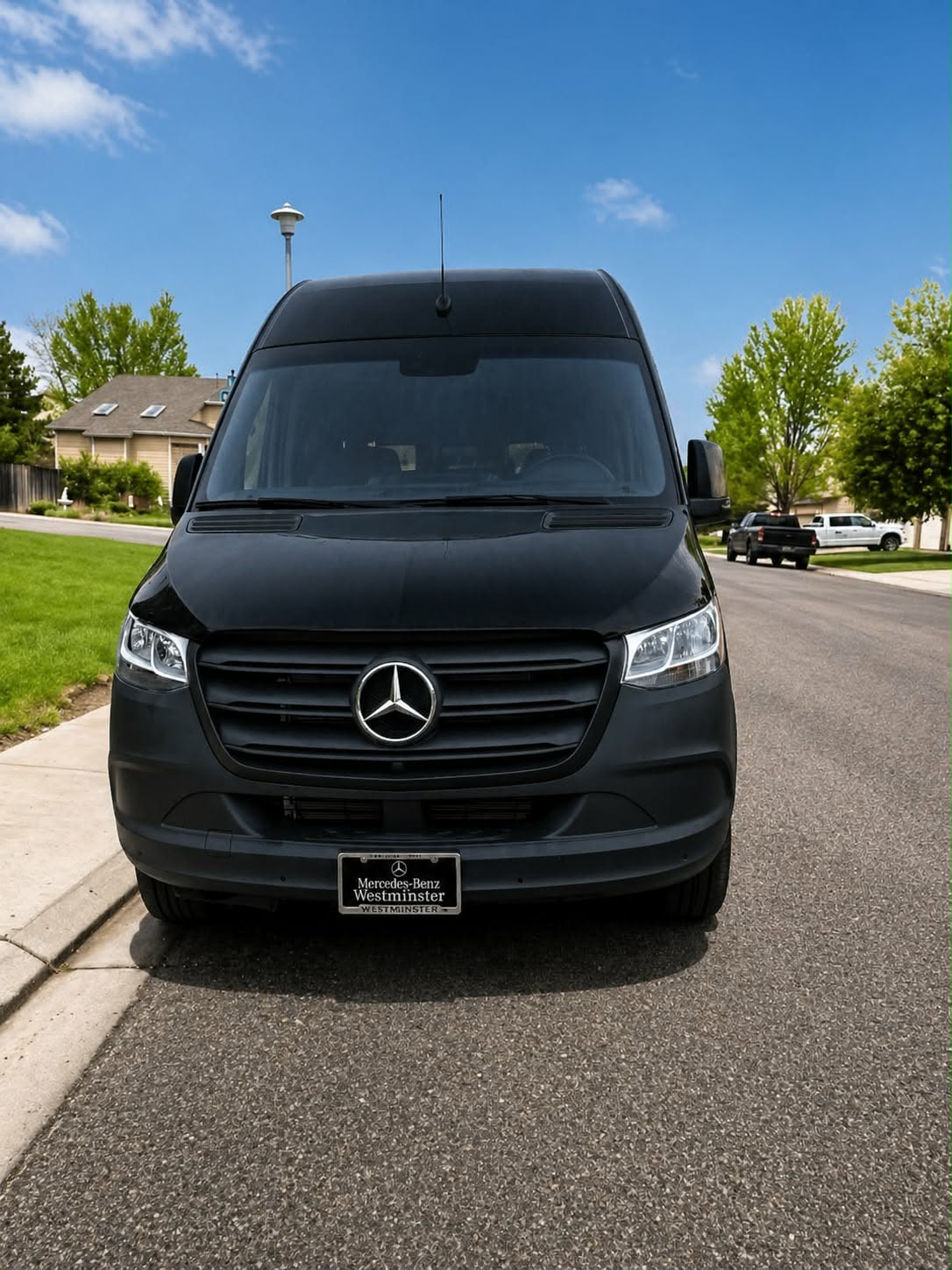 Front view of a black Mercedes-Benz Sprinter van on a Denver-area street