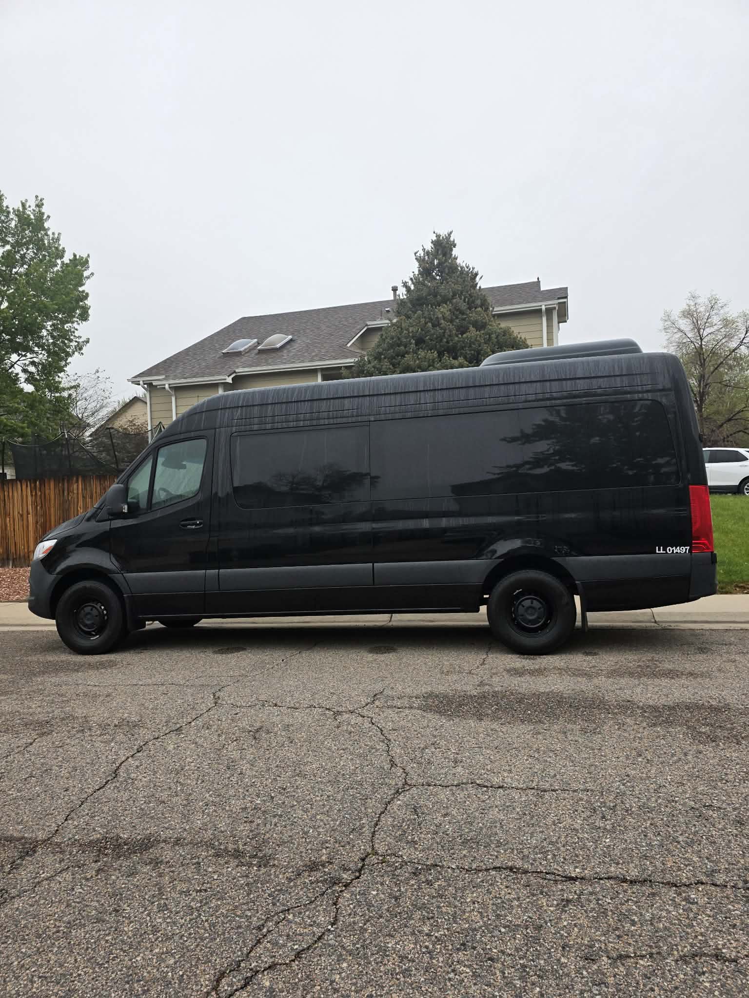 Black Mercedes-Benz Sprinter van in profile on a Denver-area street
